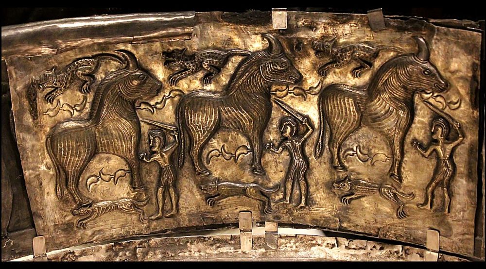 Plaque d'argent repoussé : trois taureaux entourés d'hommes armés d'épées, de chiens et de félins